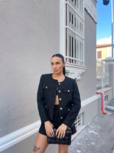 a lady wears a tube top with a black tweed jacket